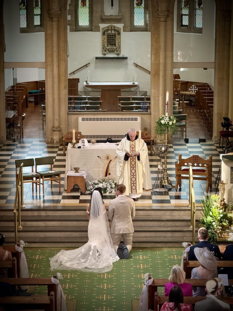 Wedding Couple having a blessing at St Thomas of canterbury church, Woodford Green, London