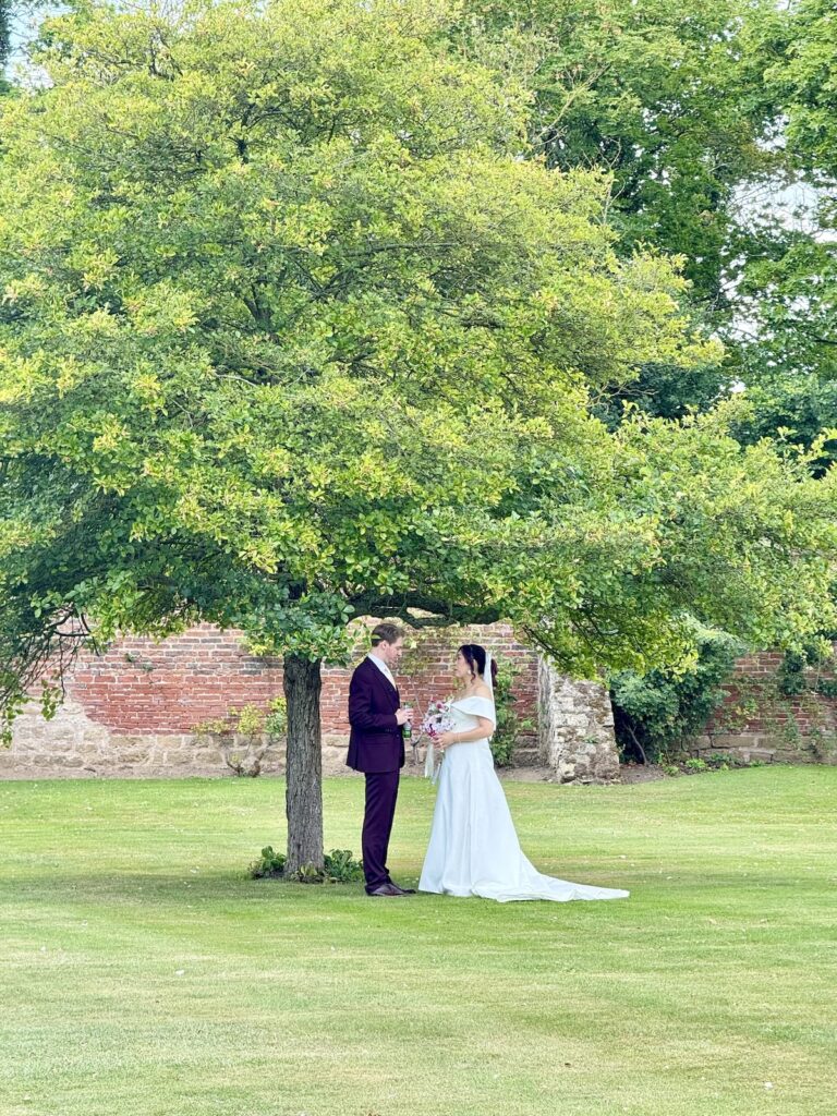 Wedding couple under a tree at Hooton Pagnell Hall in Doncaster South Yorkshire.