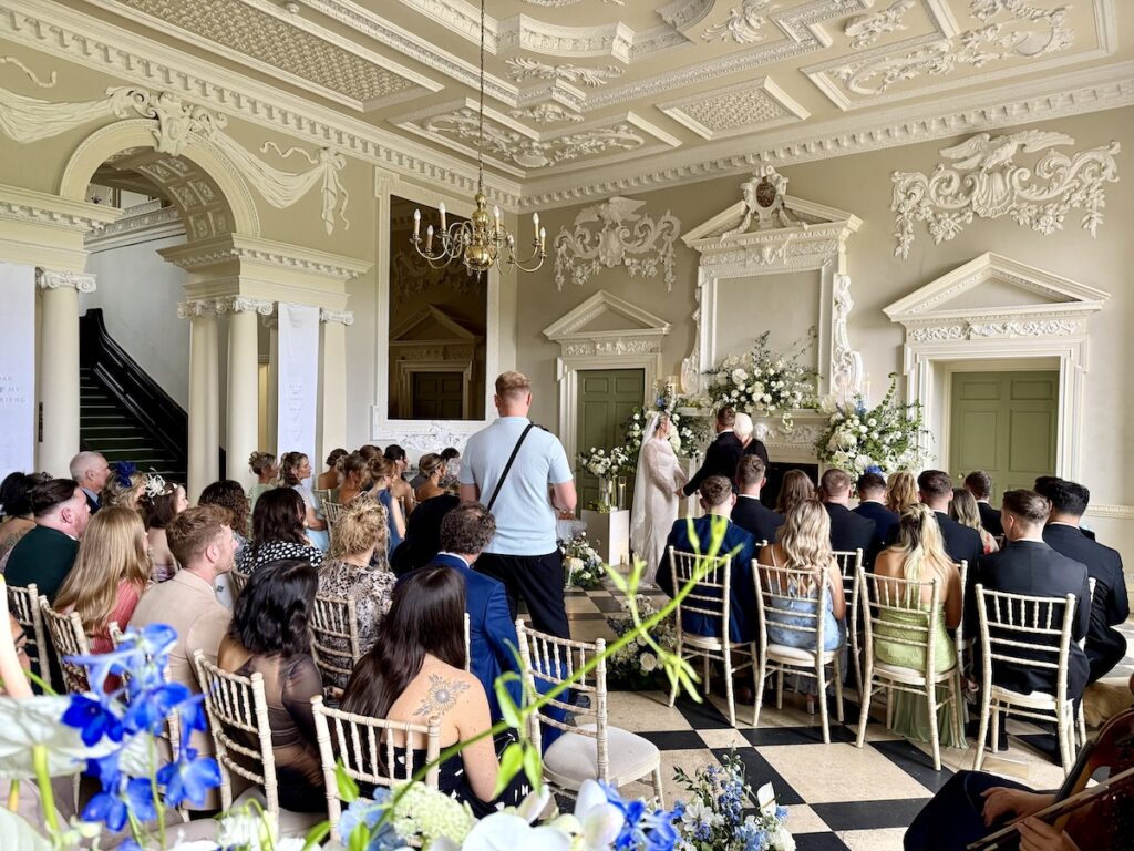 Wedding ceremony with fabulous blue and cream florals at Crowcombe Court in Somerset