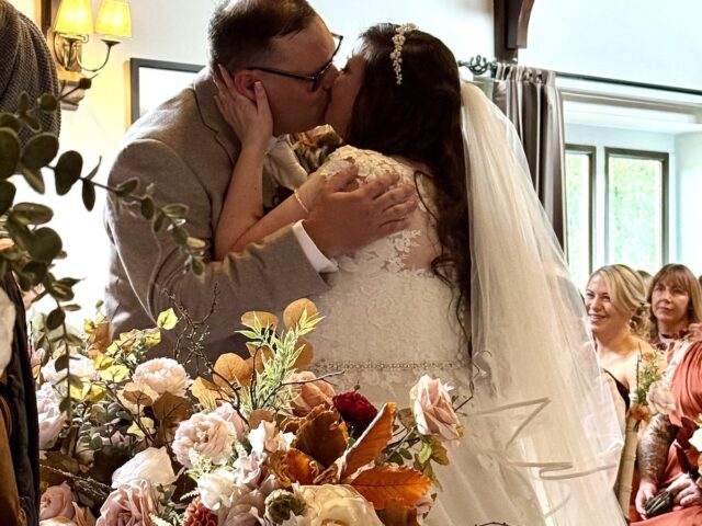 First kiss during the ceremony at Dunstan Hall Hotel in Norwich, Norfolk