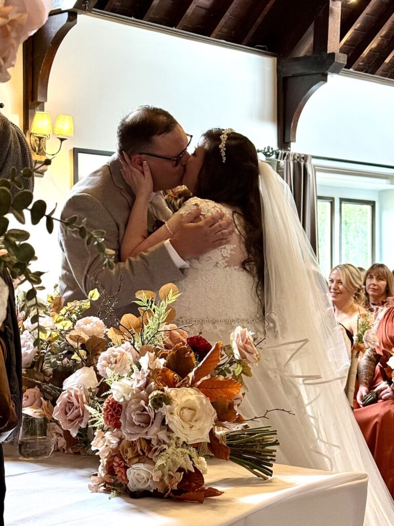 First kiss during the ceremony at Dunstan Hall Hotel in Norwich, Norfolk
