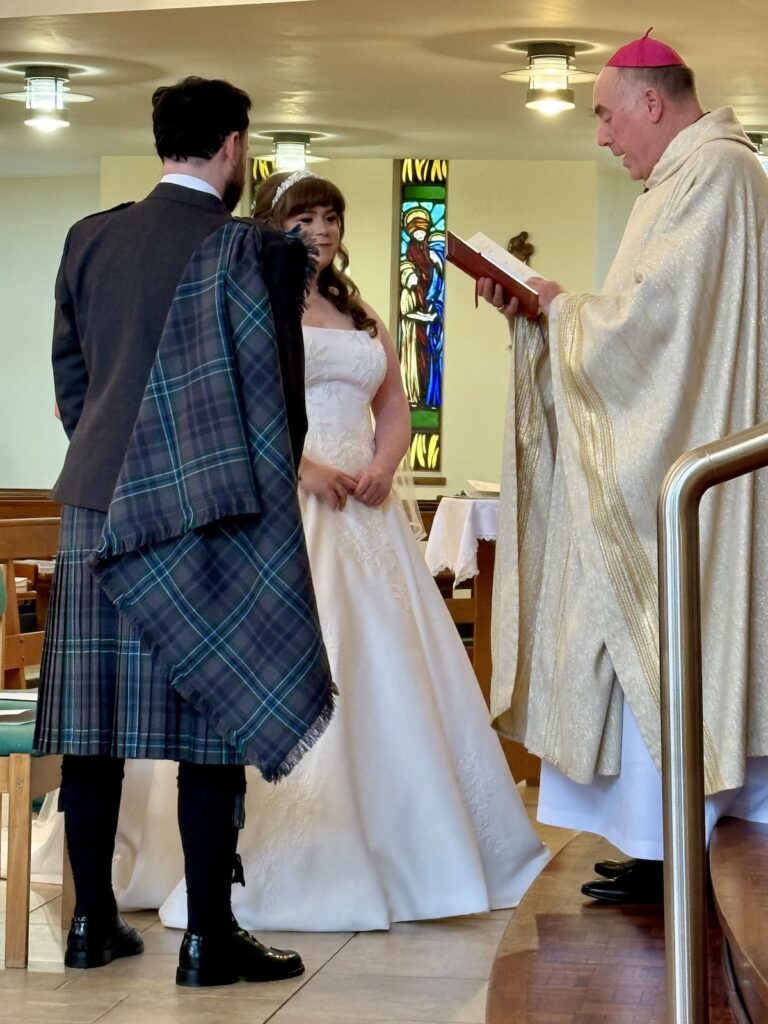 Bride and Groom with Priest at St Joseph's RC Church in Clarkston, Glasgow, Scotland