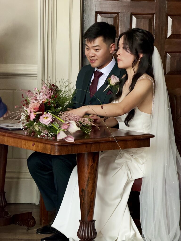 Bride and Groom signing the register at Elmore Court