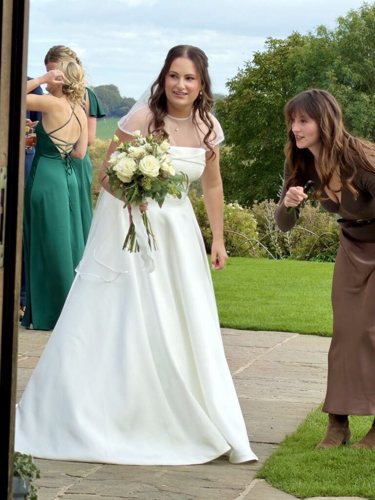 Wedding Bride with flowers in the garden at Kingscote barn in The Cotswolds